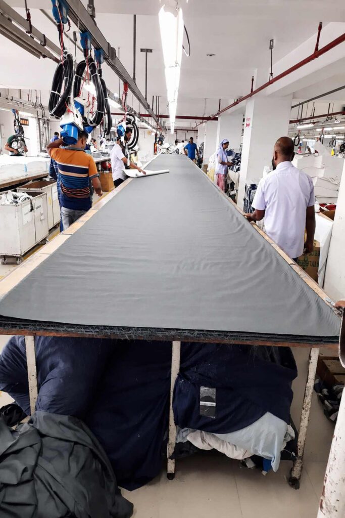 Sew Apparels factory team preparing fabric on a garment cutting table in Bangladesh